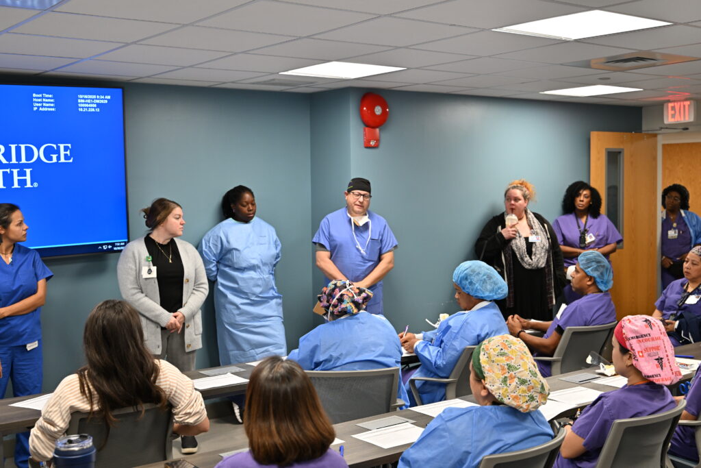 A group of nurses and doctors wear scrubs during an Infinite Legacy simulation lab.