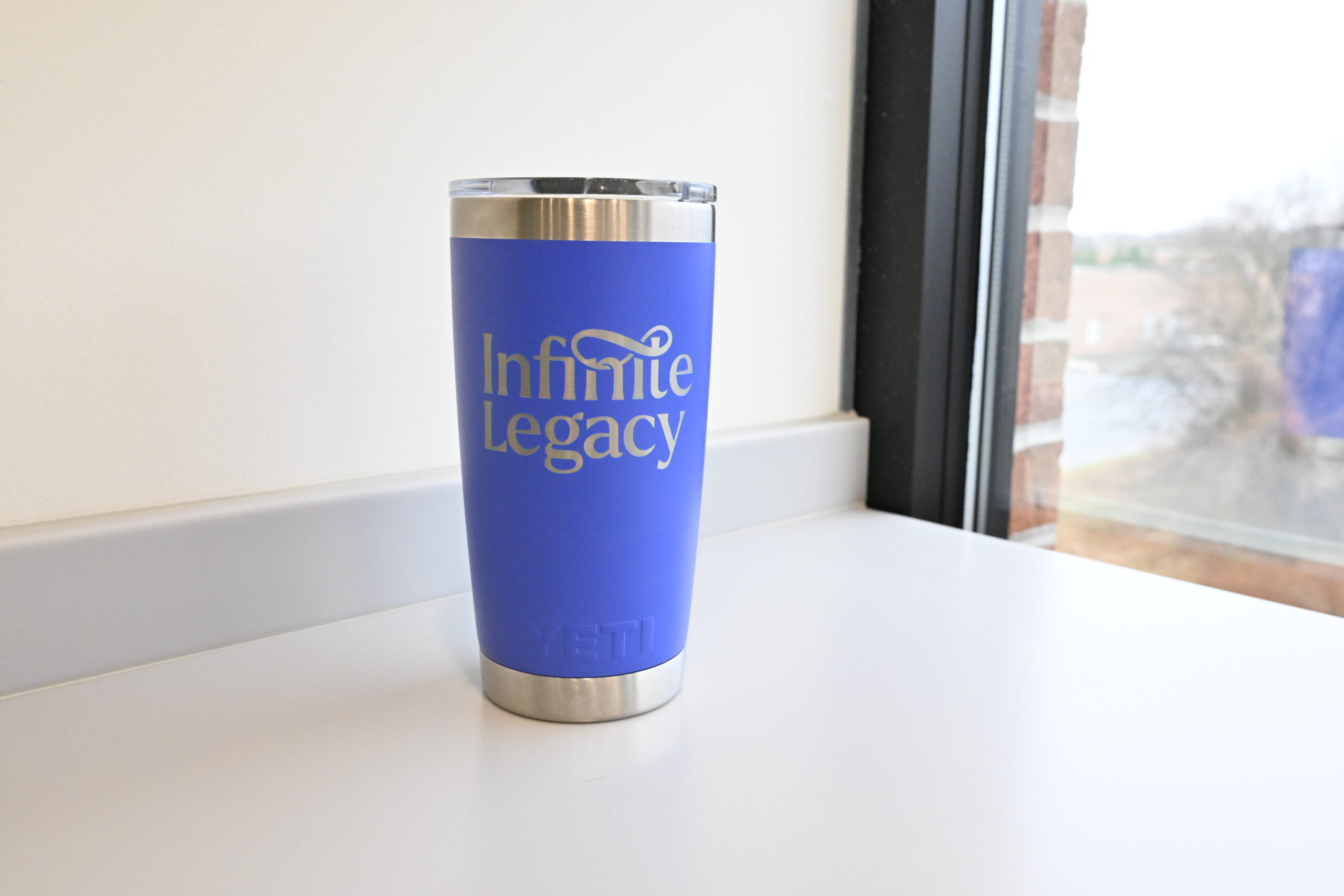 A bright purple Infinite Legacy YETI tumbler with logo.